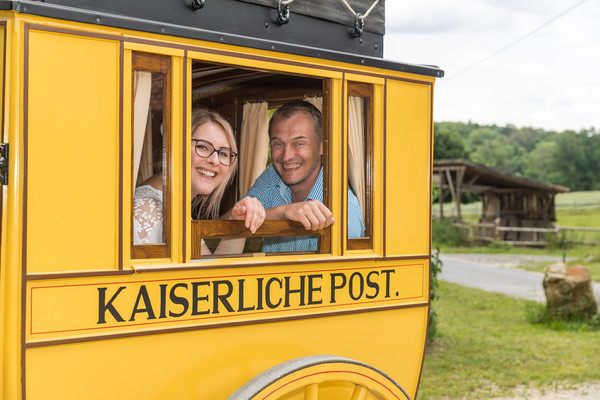 Ein Wanderpaar ist in der Tecklenburger Postkutsche unterwegs.