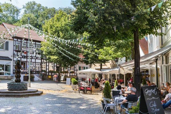 Am Marktplatz von Tecklenburg sind viele Cafés, ein Brunnen und Fachwerkhäuschen.